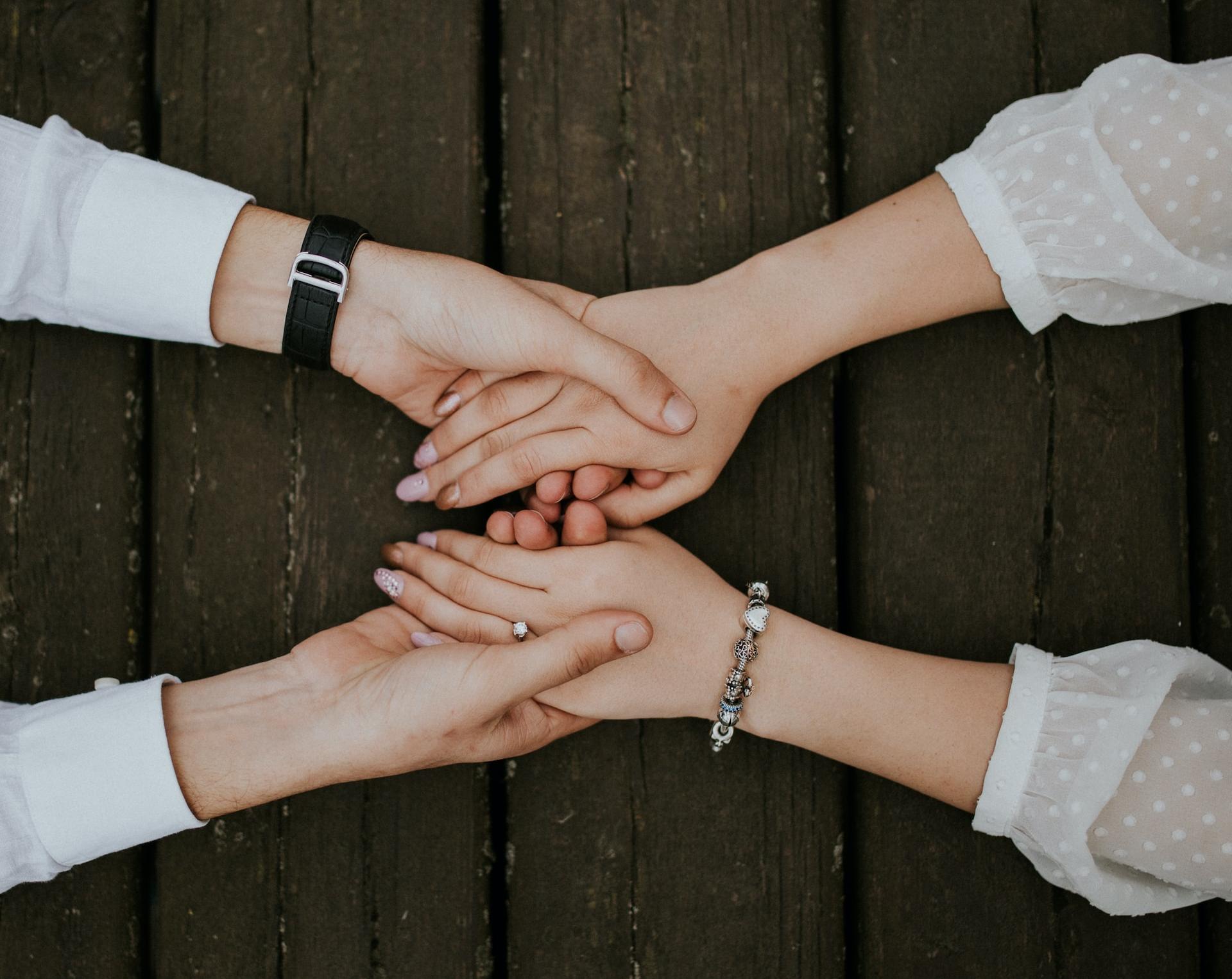flat lay photography of man and woman holding hands together